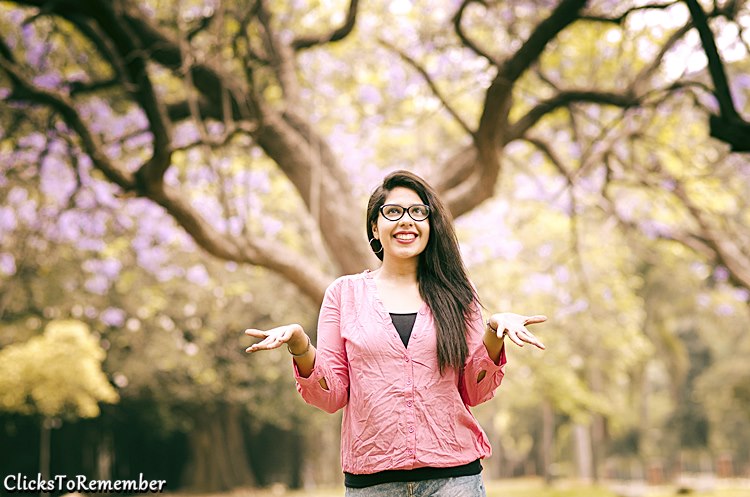 Image of a model looking happily at the flowering tree Outdoor Model Photography in Bangalore
