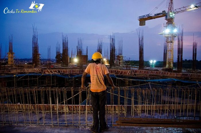 a construction worker looking at the site at twilight