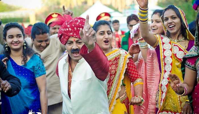 happy relatives of the groom dancing in the baraat
